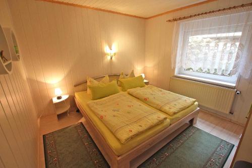 マルヒョーにあるFerienwohnung Malchow SEE 4551のベッドルーム1室(黄色い枕のベッド1台、窓付)