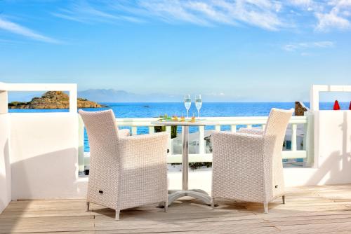 a table and chairs on a deck overlooking the ocean at Petinos Beach Hotel in Platis Yialos Mykonos