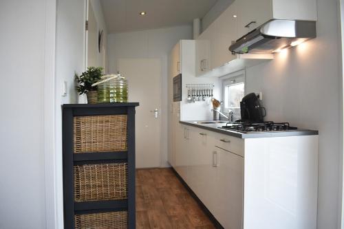 a kitchen with white cabinets and a counter top at Strandparc Nulde in Putten