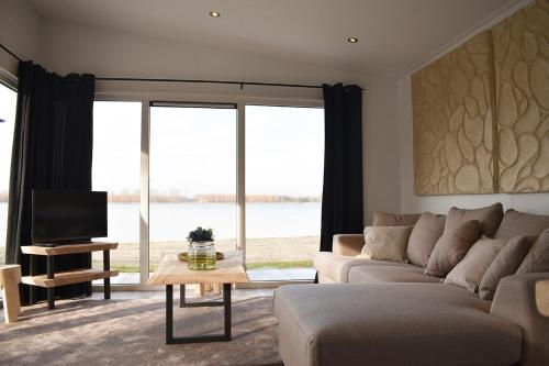 a living room with a couch and a tv at Strandparc Nulde in Putten