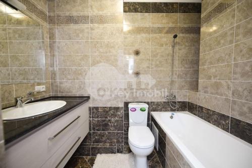 uma casa de banho com um WC, uma banheira e um lavatório. em Alba-Iulia Vip Residence em Chisinau