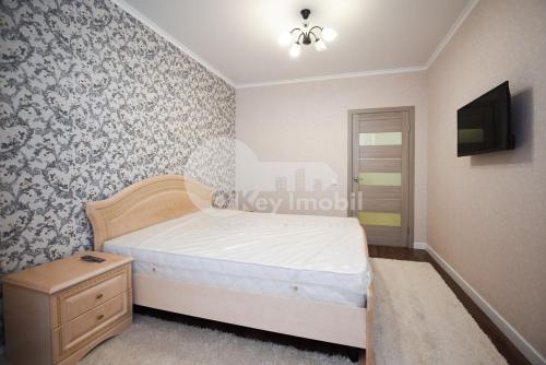 a bedroom with a bed and a tv on a wall at Alba-Iulia Vip Residence in Chişinău