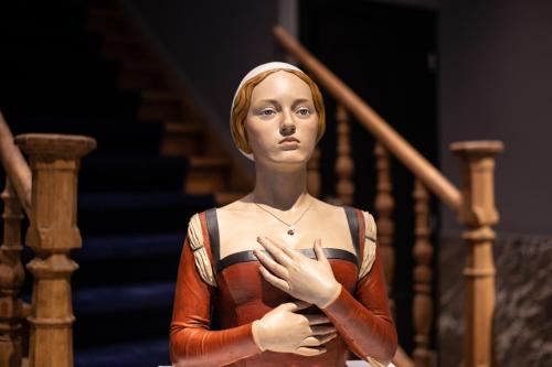 a woman standing on a staircase with her hand gesture at Boutique Hotel Sablon by CW Hotel Collection in Bruges