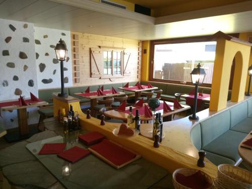 un restaurante con mesas rojas y una gran ventana en Gasthaus Krone, en Übersaxen