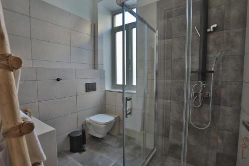 a bathroom with a toilet and a glass shower at Ederlezi Boutique Hotel in Athens