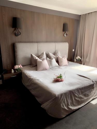 a bedroom with a large white bed with pink pillows at Atlantic Hotel - Free Parking in Sofia