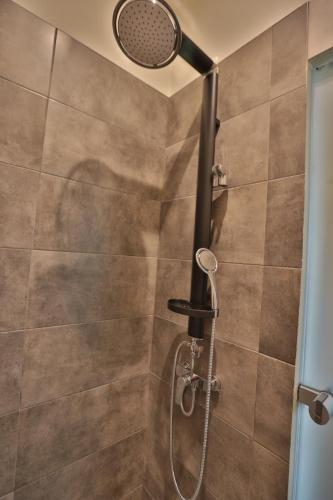 a shower with a shower head in a bathroom at Ederlezi Boutique Hotel in Athens