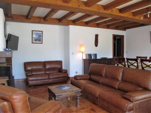 a living room with brown leather couches and a table at Holiday Home Roitelet by Interhome in Mimizan-Plage