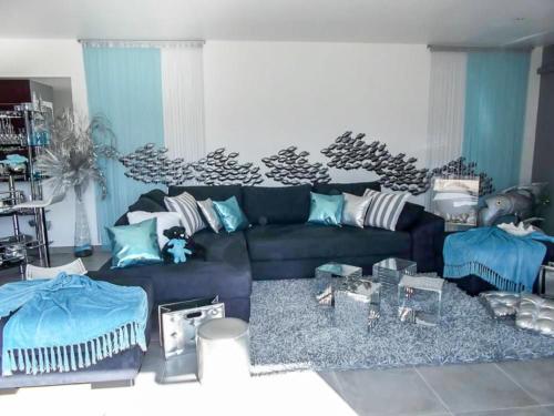 RognonasにあるHoliday Home Un petit coin de paradis by Interhomeのリビングルーム(黒いソファ、青い枕付)