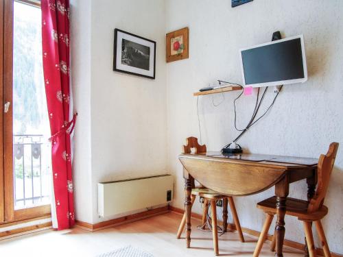 une pièce avec un bureau et une télévision au mur dans l'établissement Apartment Le Carlton-5 by Interhome, à Chamonix-Mont-Blanc