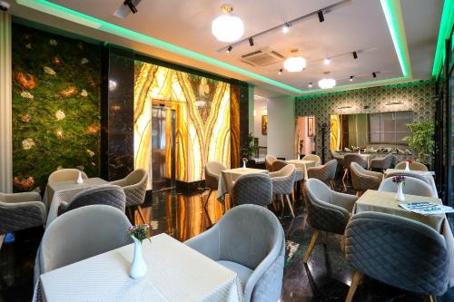 a restaurant with tables and chairs in a room at Emerald Boutique Hotel in Tirana