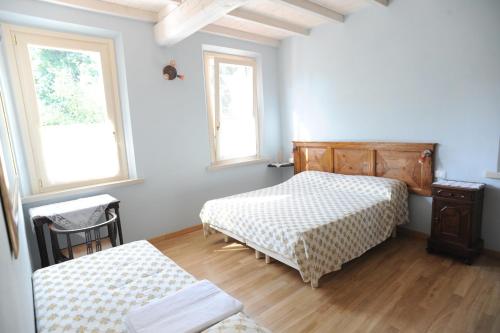 a bedroom with two beds and two windows at Il Giardino Del Conte Custoza in Marmirolo