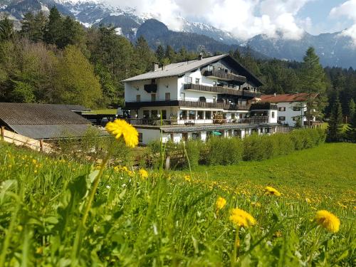 un grande edificio su una collina con un campo di fiori di Canisiusbrünnl Self- Check in a Innsbruck