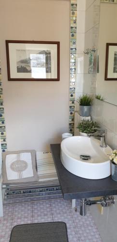 Habitación con baño con lavabo blanco grande. en Un Tetto Di Stelle Deluxe Home, en Salerno