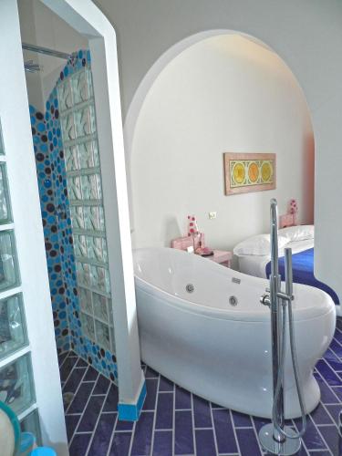 a bathroom with a white tub in a room at Hotel Holiday in Praiano