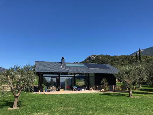 a house with a black roof in a field at Da La Babi B&B in Arco