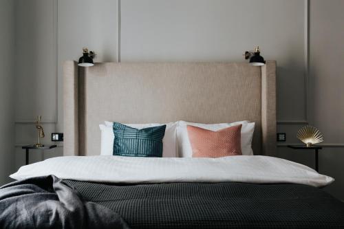 ブダペストにあるTG Hotel Apartments Budapestのベッドルーム1室(大型ベッド1台、カラフルな枕付)