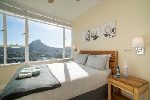 sypialnia z łóżkiem i widokiem na góry w obiekcie Disa Park 16th Floor Apartment with City Views w Kapsztadzie