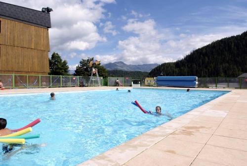 un groupe de personnes nageant dans une piscine dans l'établissement Azureva Les Karellis - Skipass Inclus!, à Montricher-le-Bochet