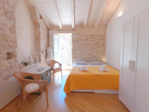 a bedroom with a bed and a table and a window at Historic Piazza House & Romantic Hidden Garden in Hvar