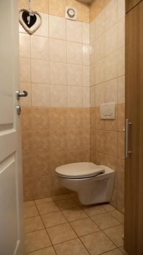a bathroom with a toilet in a tiled room at Aart Apartman in Csopak