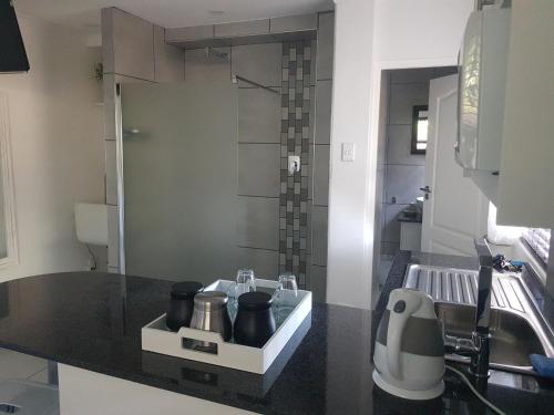 a small bathroom with a sink and a shower at Alyssa's Inn Boutique Guesthouse in Cape Town