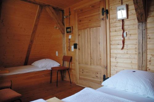 a room with two beds in a wooden cabin at Schloss Herberge Hohenerxleben in Hohenerxleben