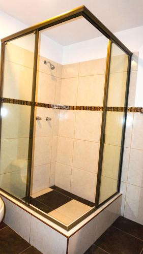 a shower with glass doors in a bathroom at Lunandina Huaraz in Huaraz