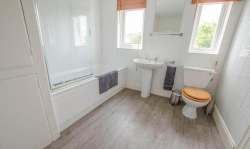a white bathroom with a toilet and a sink at Cloudbreak Braunton, Sleeps 8 - Hot Tub hire - Dog Friendly in Braunton