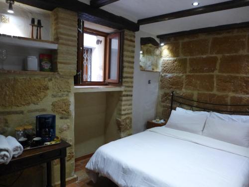 1 dormitorio con cama y pared de ladrillo en No1 CasaTosca Javea, Pequeña Habitación con baño en el Centro del Casco Antiguo, en Jávea