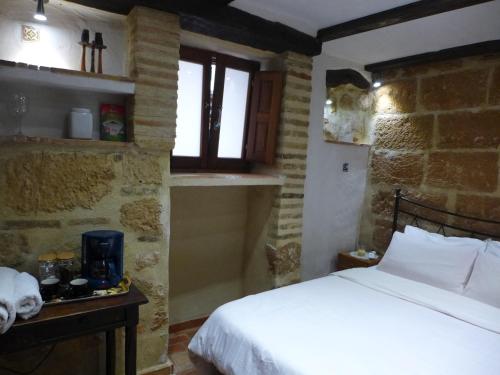 a bedroom with a bed in a stone walled room at No1 CasaTosca Javea, Pequeña Habitación con baño en el Centro del Casco Antiguo in Jávea