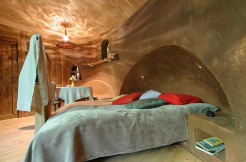 a bedroom with a bed with a stone wall at Omaya Eco Village in Gaytaninovo