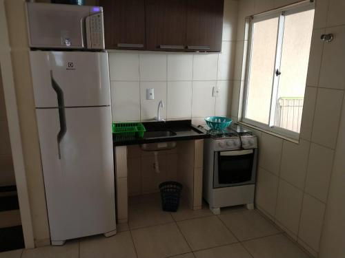 eine Küche mit einem weißen Kühlschrank und einem Herd in der Unterkunft Residencial Melfi 3 Ap. 7 Fundos in Bombinhas