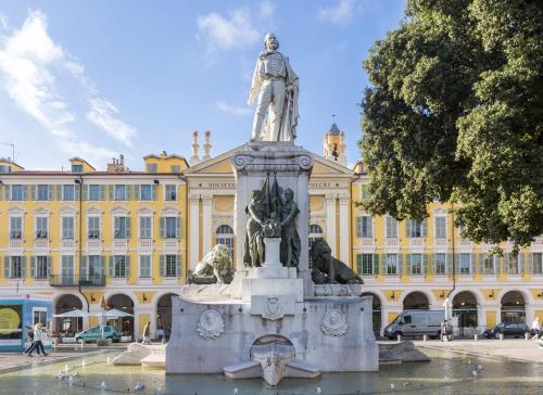 uma estátua em frente a um grande edifício em Appart Hotel Garibaldi em Nice
