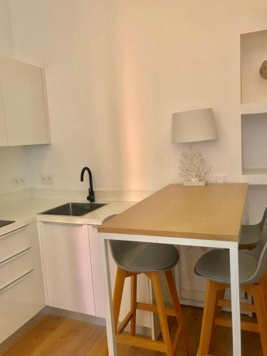 une cuisine avec un évier et une table avec deux chaises dans l'établissement Appart Hotel Garibaldi, à Nice