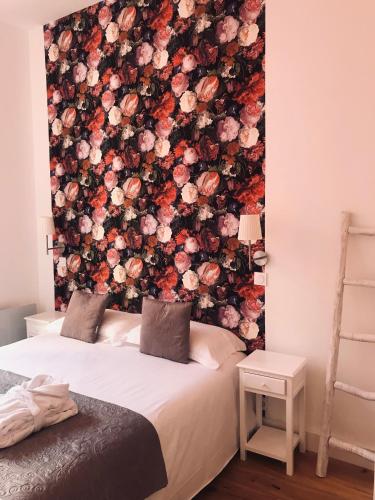 - une chambre avec un mur fleuri derrière un lit dans l'établissement Appart Hotel Garibaldi, à Nice