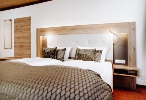 a bedroom with a large bed with a large headboard at Hotel Frauensteiner Hof in Frauenstein