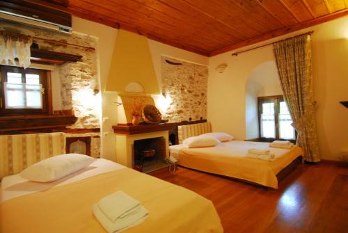モウレシにあるArchontiko Iatridisのベッドルーム1室(ベッド2台、暖炉付)