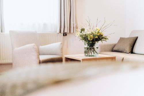 a living room with a vase of flowers on a table at Hotel Frauensteiner Hof in Frauenstein