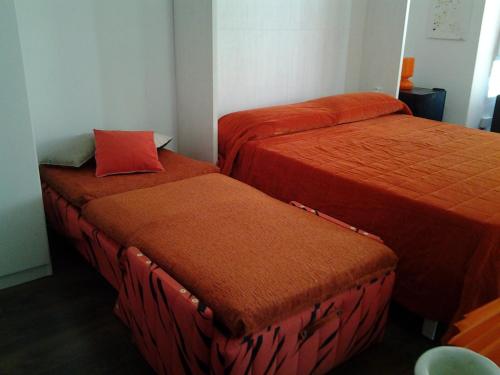two beds with orange covers in a room at Apartamento Estudio Linea de Playa in Vinaròs