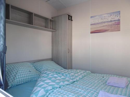 a bedroom with a bed with blue comforter at Chalet Joleen IJmuiden aan zee, vlakbij het strand in IJmuiden