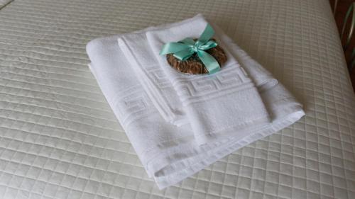 a white towel with a green bow on a bed at La Badia 11 in Cava deʼ Tirreni