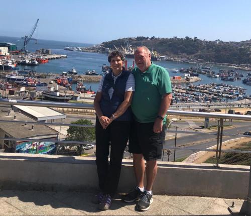 two men standing on a ledge in front of a harbor at Hostal Panorámico in San Antonio