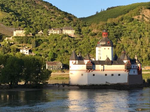 a large white lighthouse sitting in the middle of a river at Kirchhausen in Oberwesel