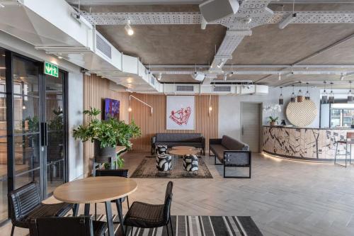 a lobby with tables and chairs in a building at Brand new penthouse with waterfront views in Cape Town