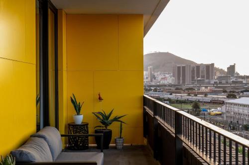 a yellow balcony with a view of a city at Brand new penthouse with waterfront views in Cape Town