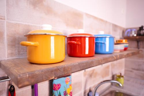 four pots sitting on a shelf in a kitchen at Wanderlust Hostel in Almaty