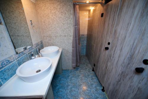 a bathroom with a sink and a toilet and a shower at Wanderlust Hostel in Almaty