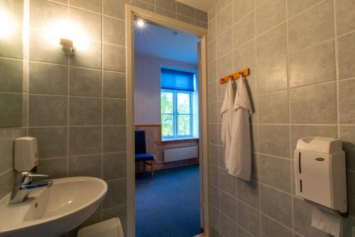 ein Bad mit einem Waschbecken, einem WC und einem Fenster in der Unterkunft Villa Kuus Sõlme - Sea View Holiday Home in Kuressaare