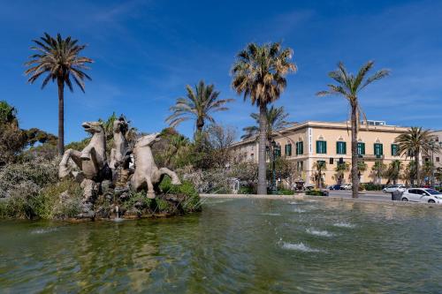 a fountain in the water in front of a building at Room Of Andrea Hotel in Trapani